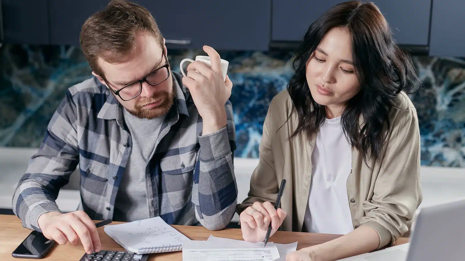 Couple reviewing household finances and life insurance coverage at a kitchen table
